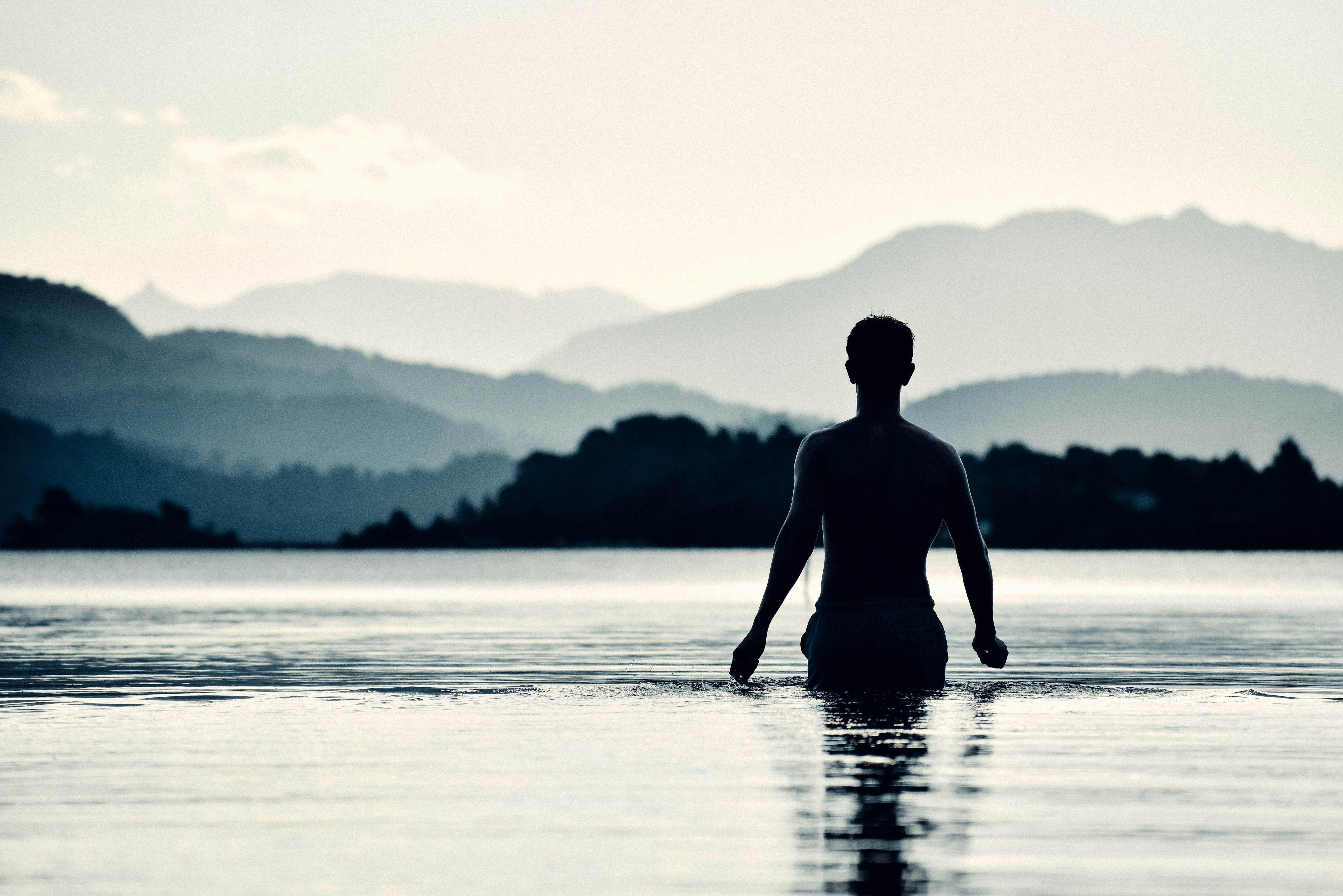 man in black wet suit standing on water