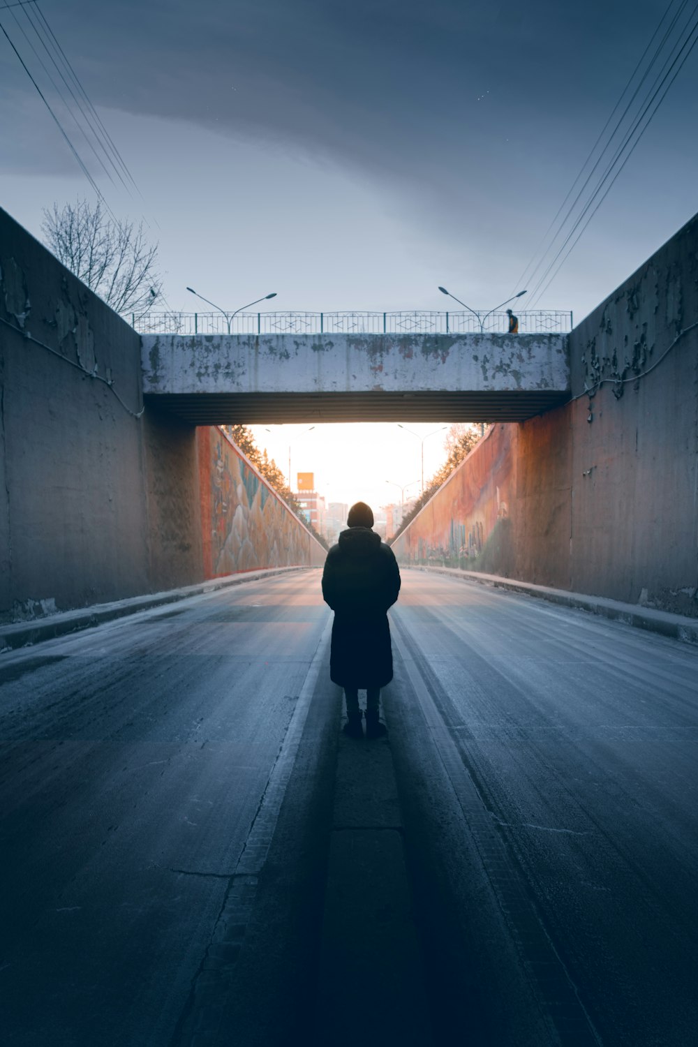 person in black jacket and pants walking on road during daytime