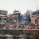 people riding on boat on river near buildings during daytime