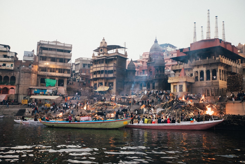 people riding on boat on river near buildings during daytime