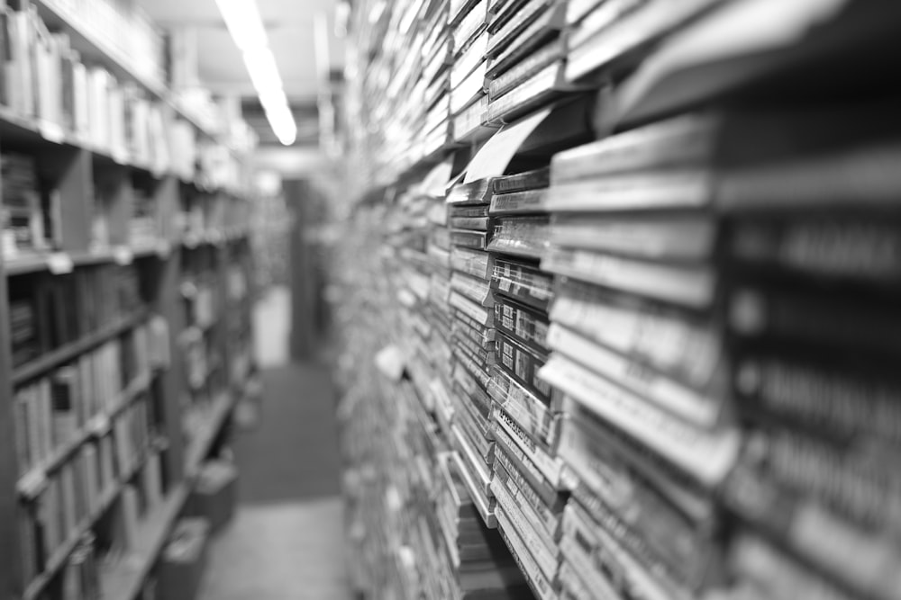 grayscale photo of books on shelves