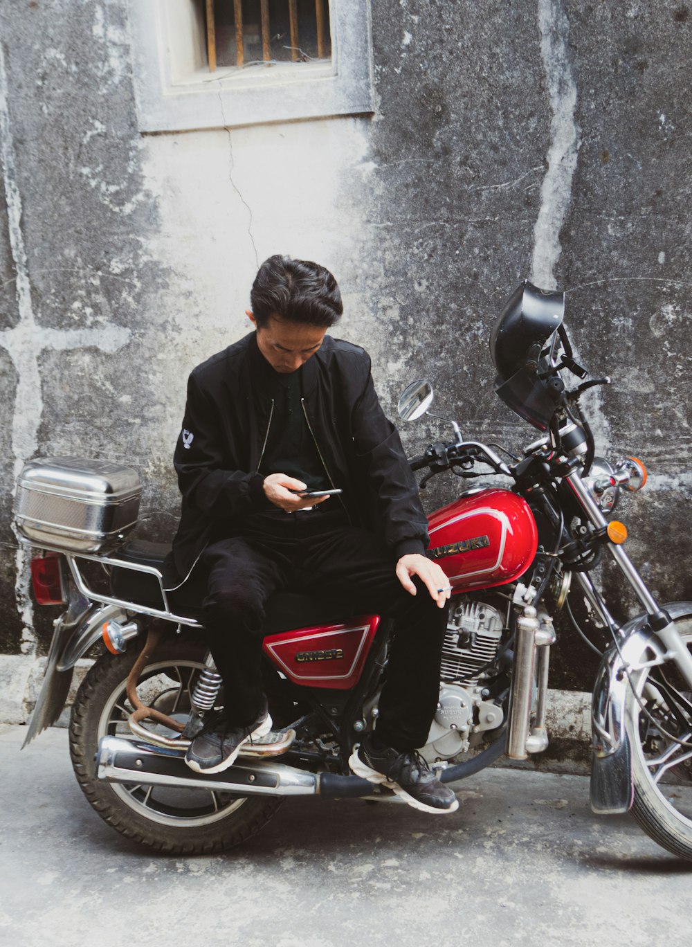 man in black jacket riding red motorcycle