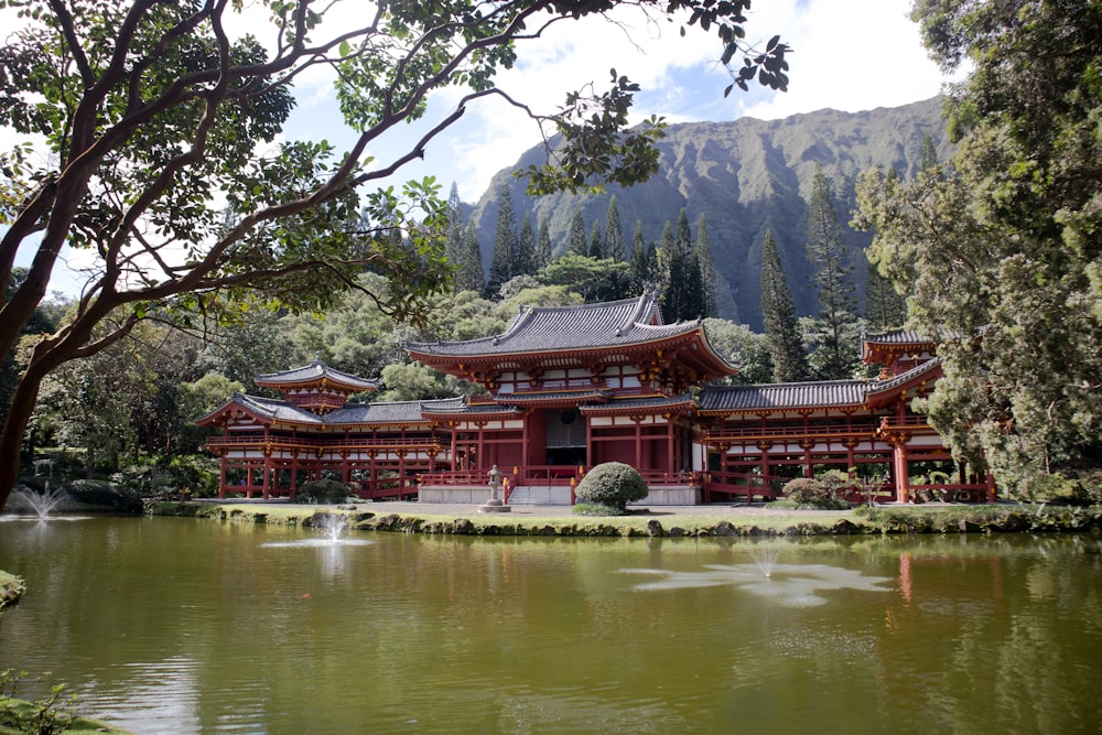 湖の近くの赤と白の寺院と昼間の緑の木々