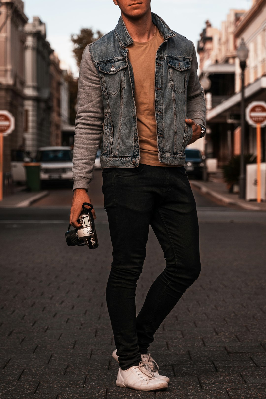 person in blue denim jacket and black pants holding black smartphone