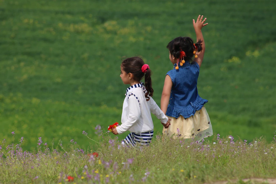 Two girls running through a meadow of wildflowers