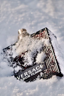 Close-up of a purple earlobe lotion bottle with delicate Santa-inspired snowflake designs.