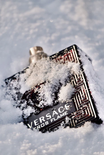 Close-up of a purple earlobe lotion bottle with delicate Santa-inspired snowflake designs.