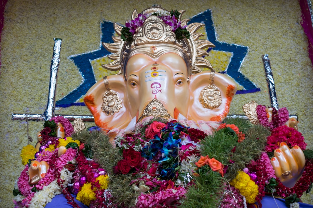 gold buddha figurine on pink and blue flowers