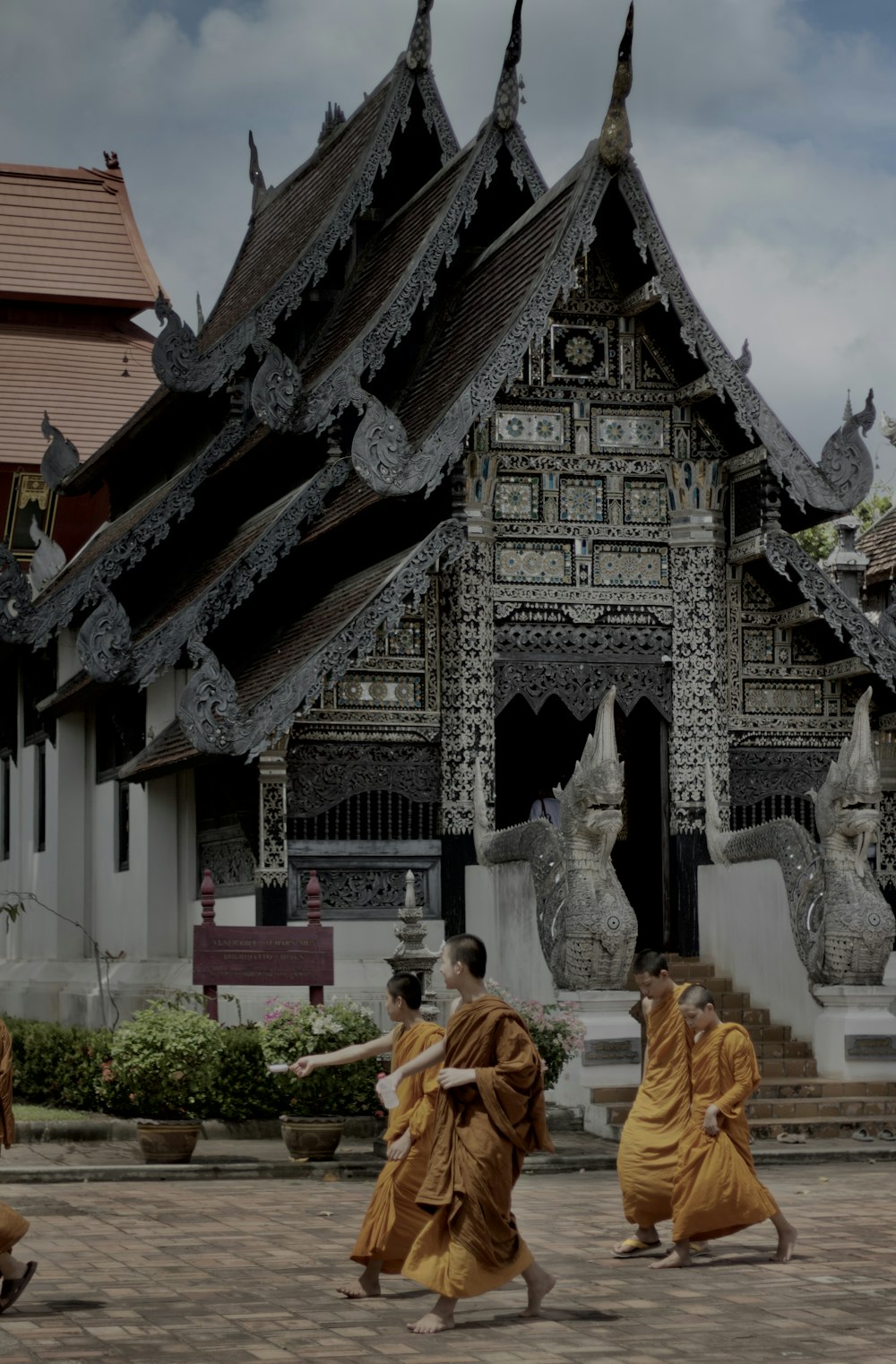 a group of monks walking in front of a building