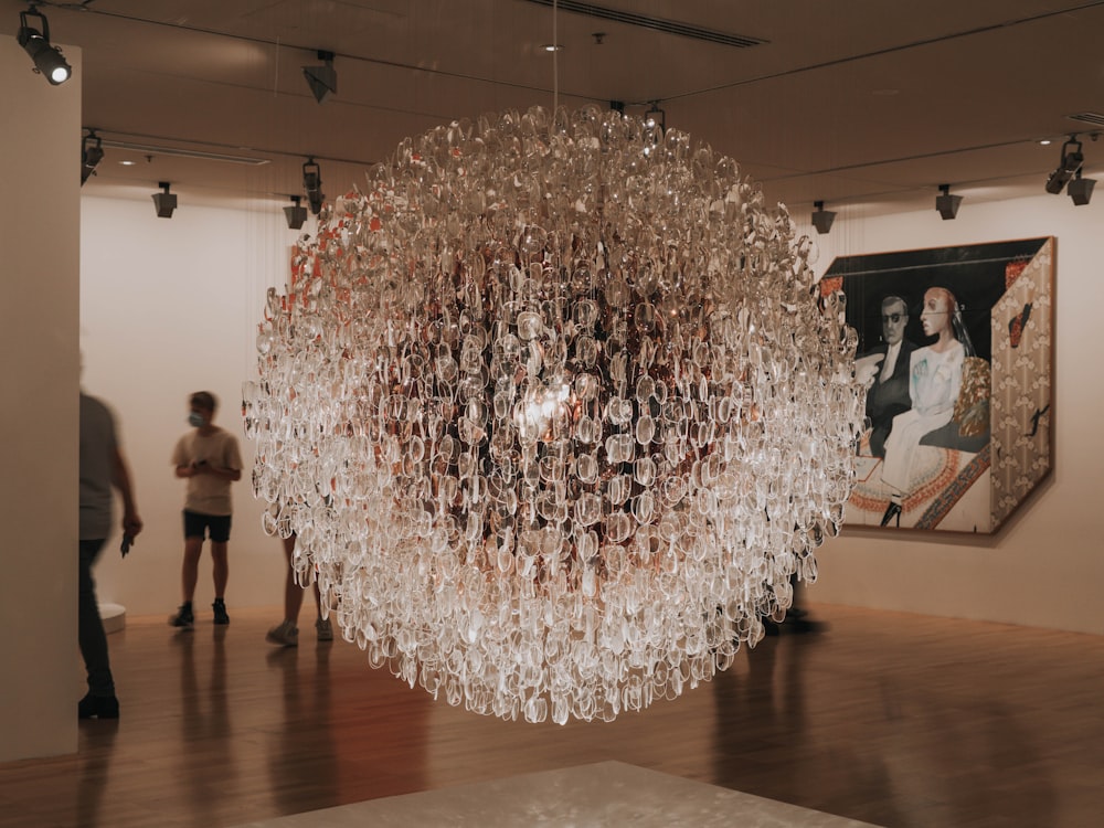 people standing under round white and brown chandelier