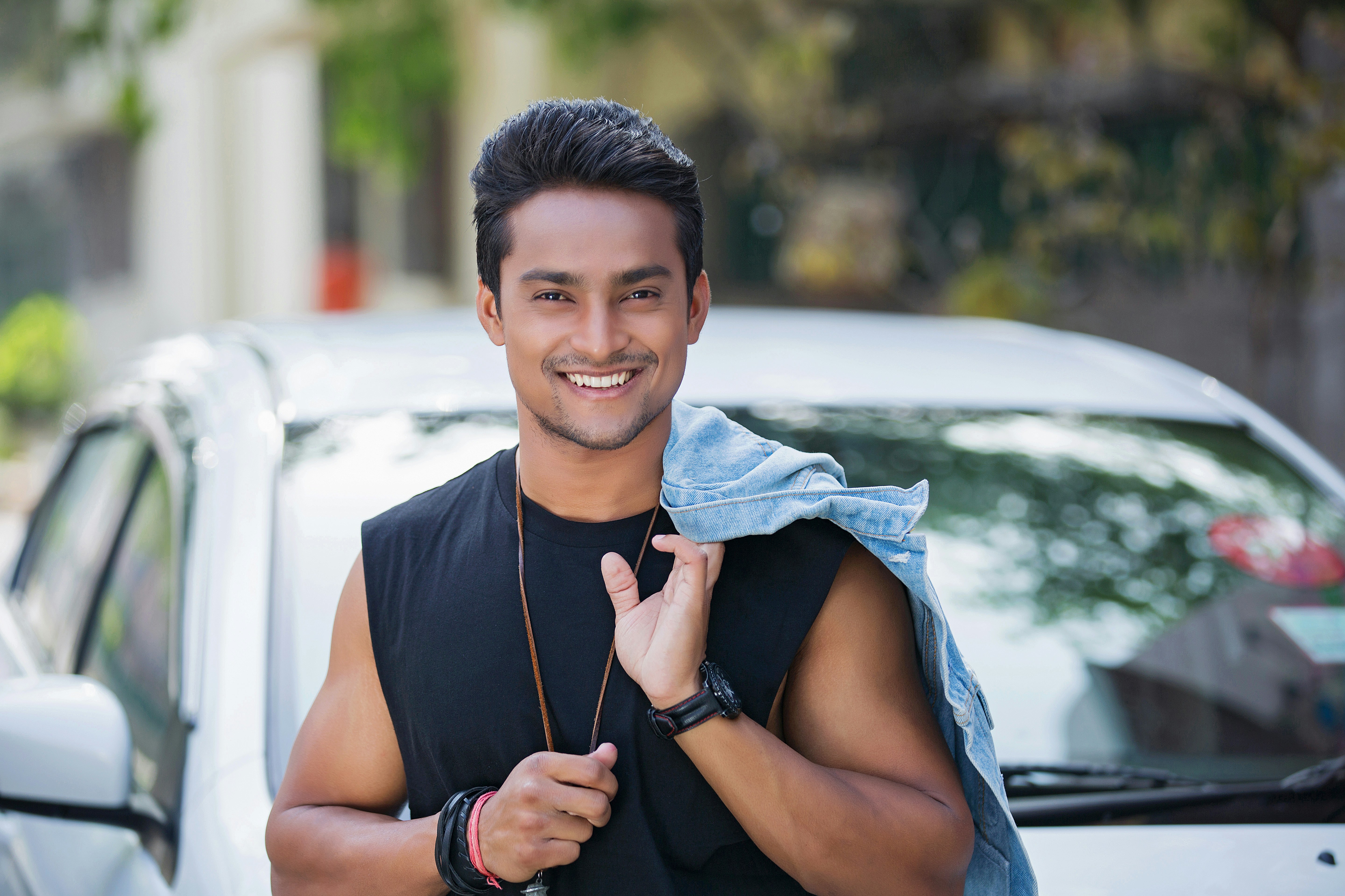 smiling boy in black tank top wearing blue scarf