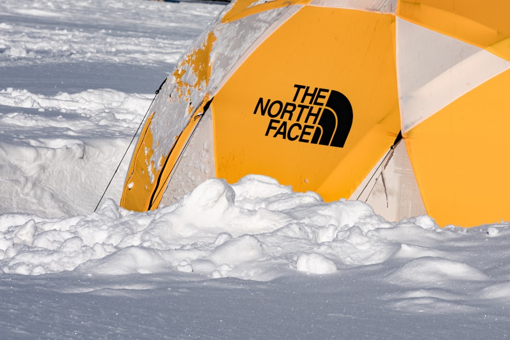 Gelbes Zelt tagsüber auf schneebedecktem Boden