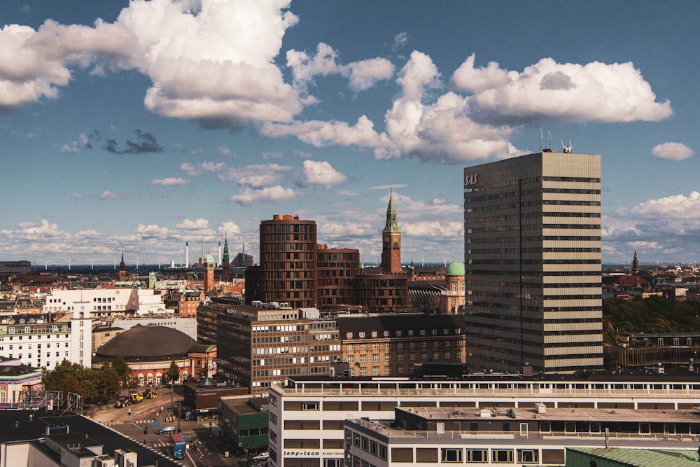 city buildings under white clouds and blue sky during daytime