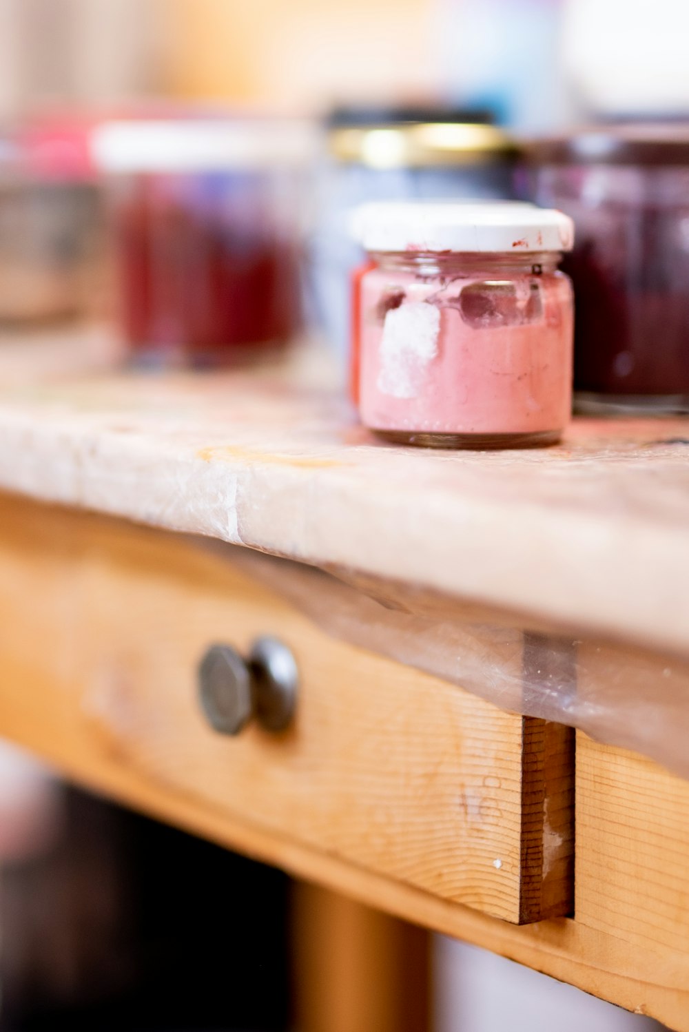 Frasco con etiqueta roja y blanca sobre mesa de madera marrón