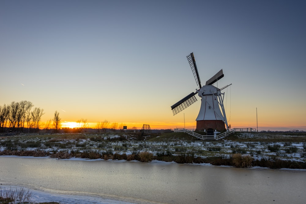 windmill on brown field during sunset