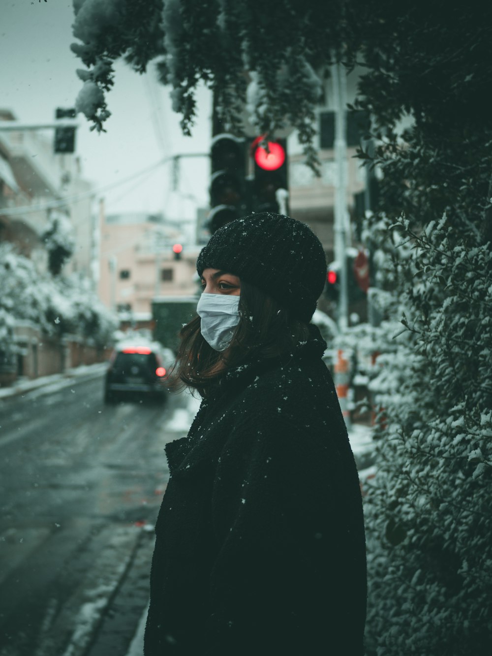 person in black hoodie standing on road during daytime