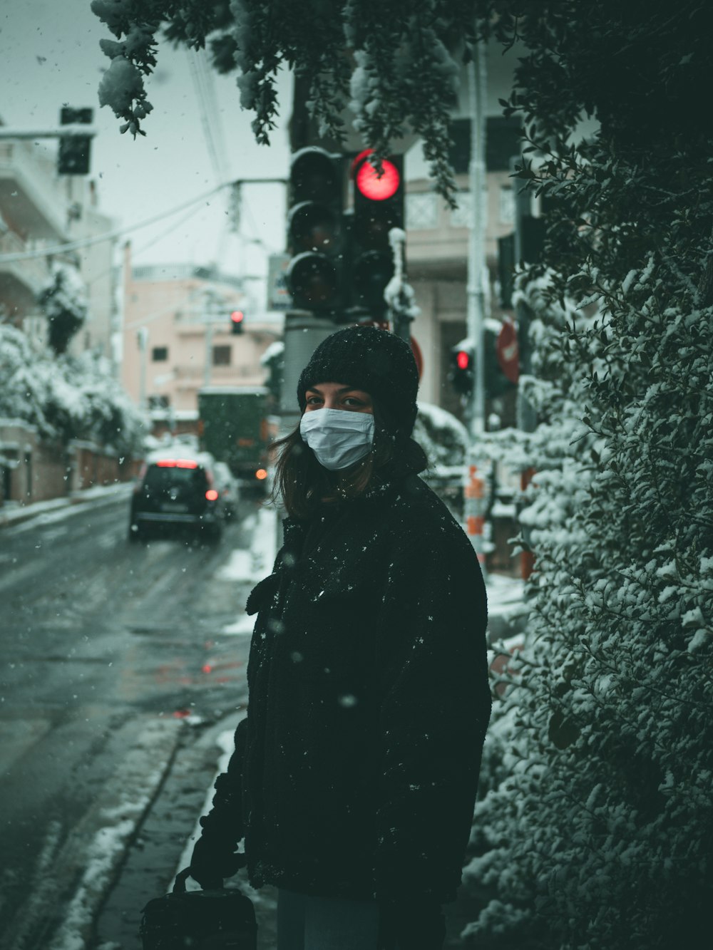 person in black hoodie standing on road during daytime