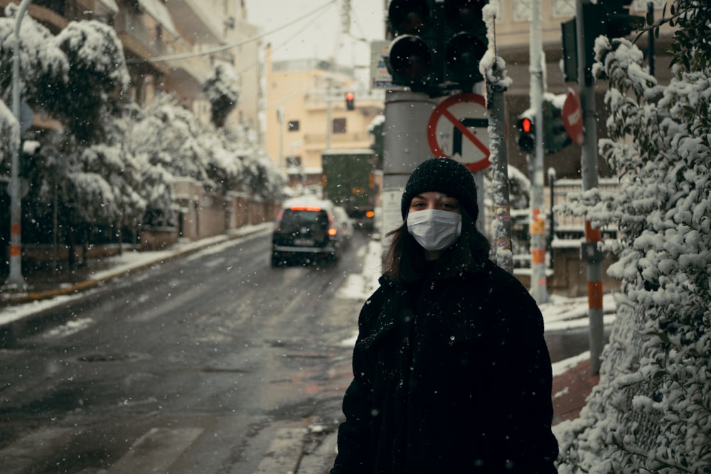 person in black hoodie standing on road during daytime