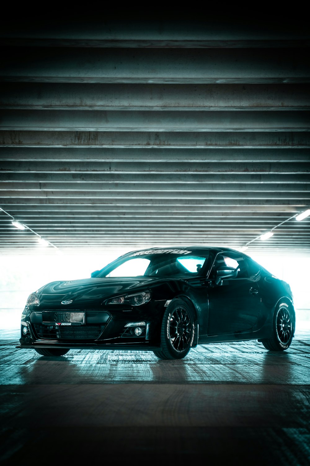 black porsche 911 parked in front of white wall