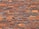 A pattern of red and orange bricks arranged in a horizontal layout, featuring variations in texture and shade. The mortar lines between the bricks are visible and uniform, providing a consistent and orderly appearance.