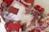 An open sketchbook features watercolor art with splashes of red, orange, and pink hues. Surrounding the sketchbook are various art and lifestyle objects, including red headphones, paint color swatches, a miniature red car, butterfly cutouts, paint swatches, a model house, and brass wax seals.
