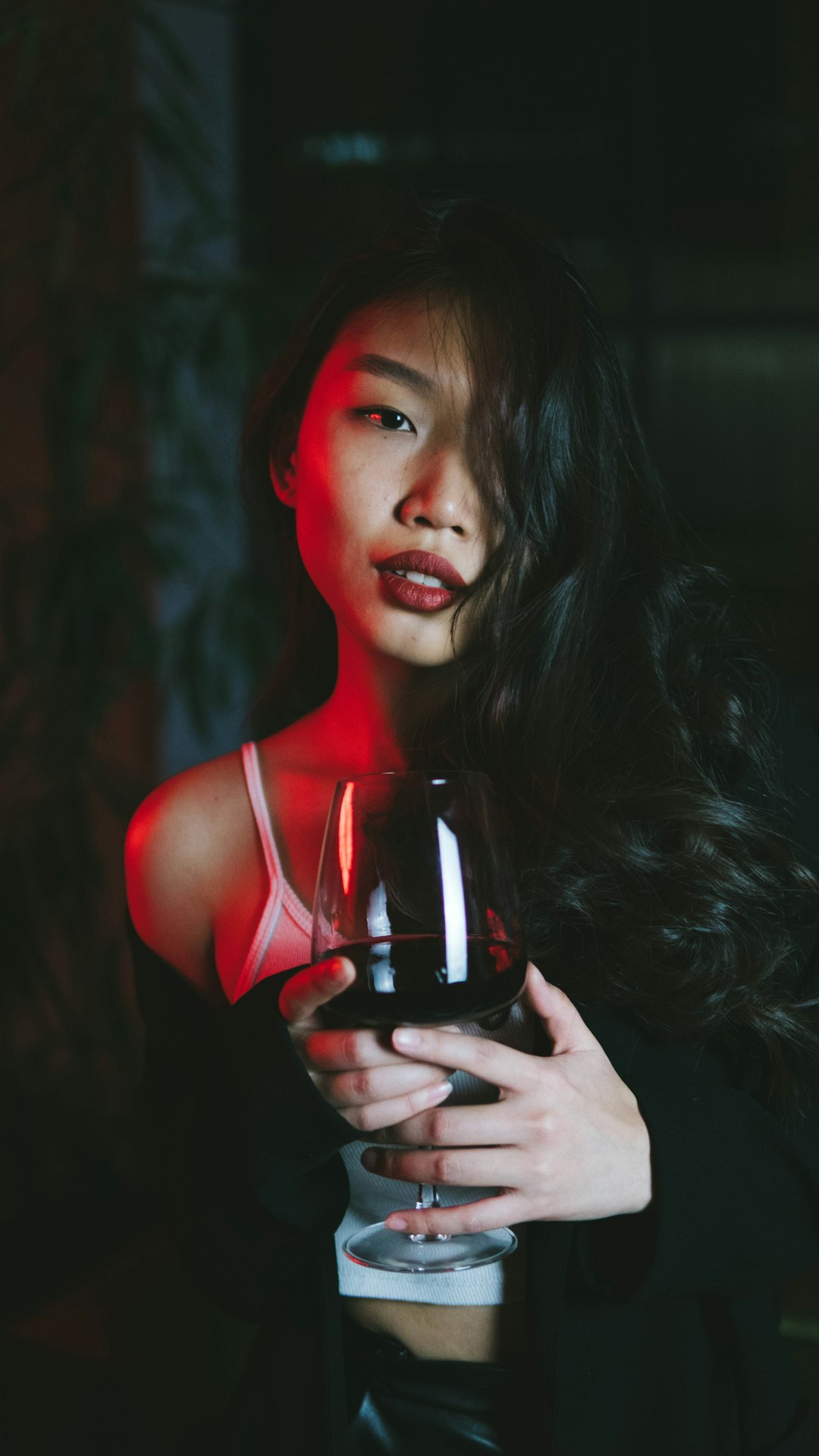 woman in red tank top holding wine glass