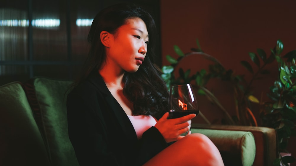 woman in black blazer holding clear drinking glass