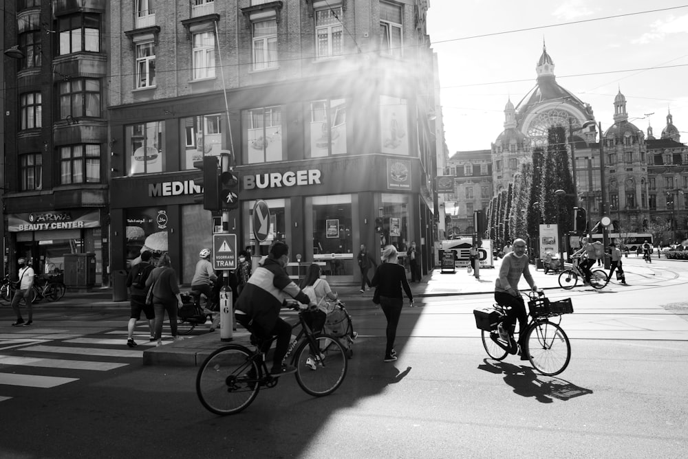grayscale photo of people riding bicycles on road