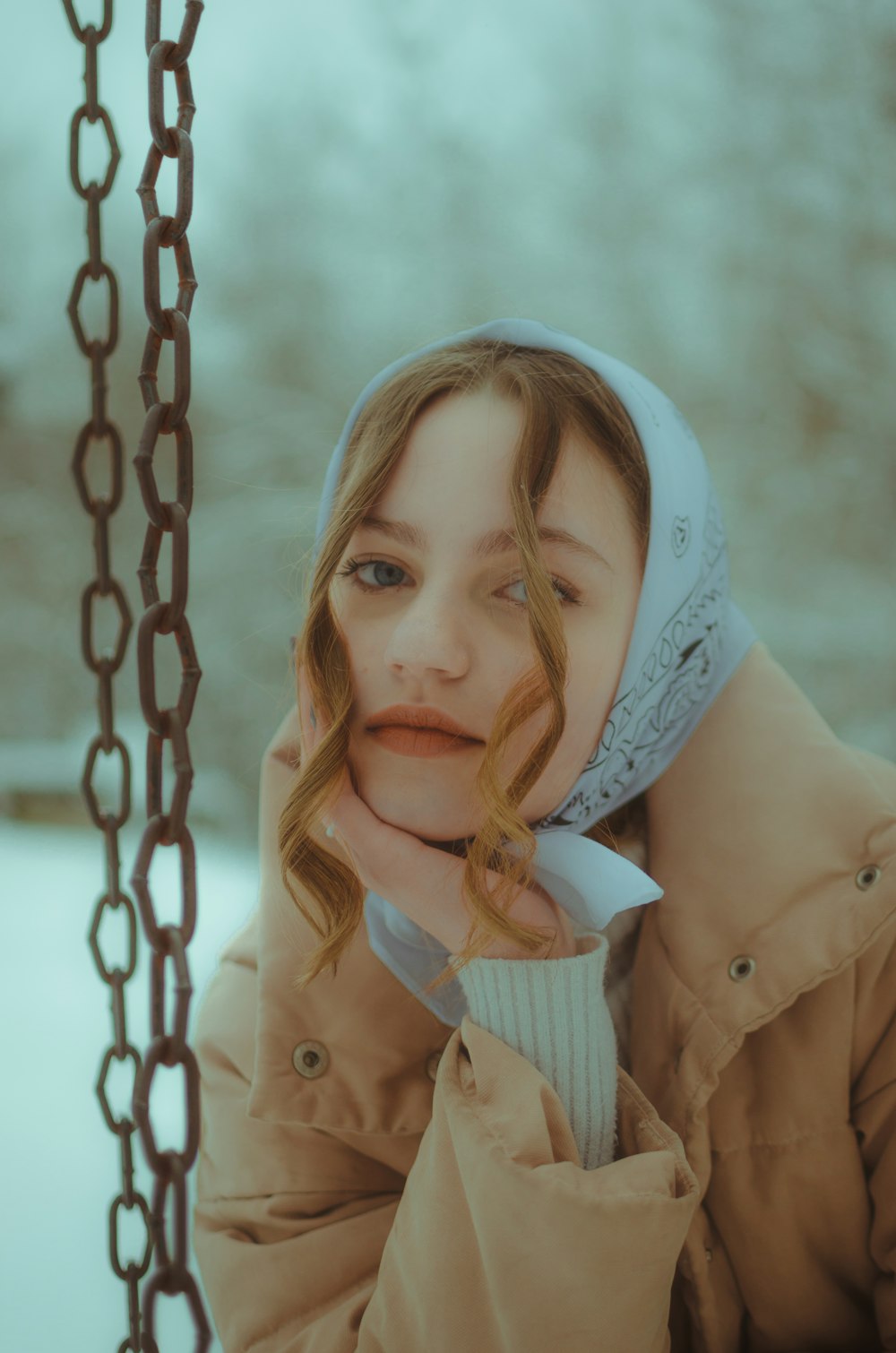 girl in brown coat on swing during daytime