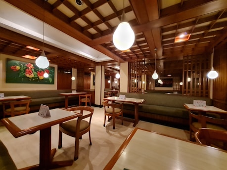 A cozy restaurant interior with wooden tables and soft lighting creating a welcoming atmosphere.