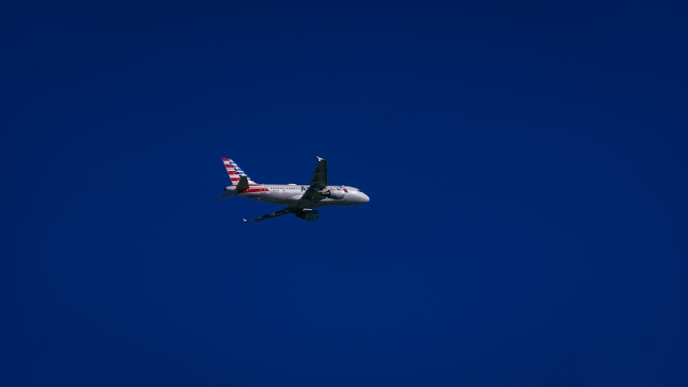 white and red airplane in mid air