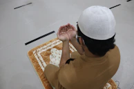 Close-up of hands raised in dua inside Masjid e Nabvi, showing devotion and hope.