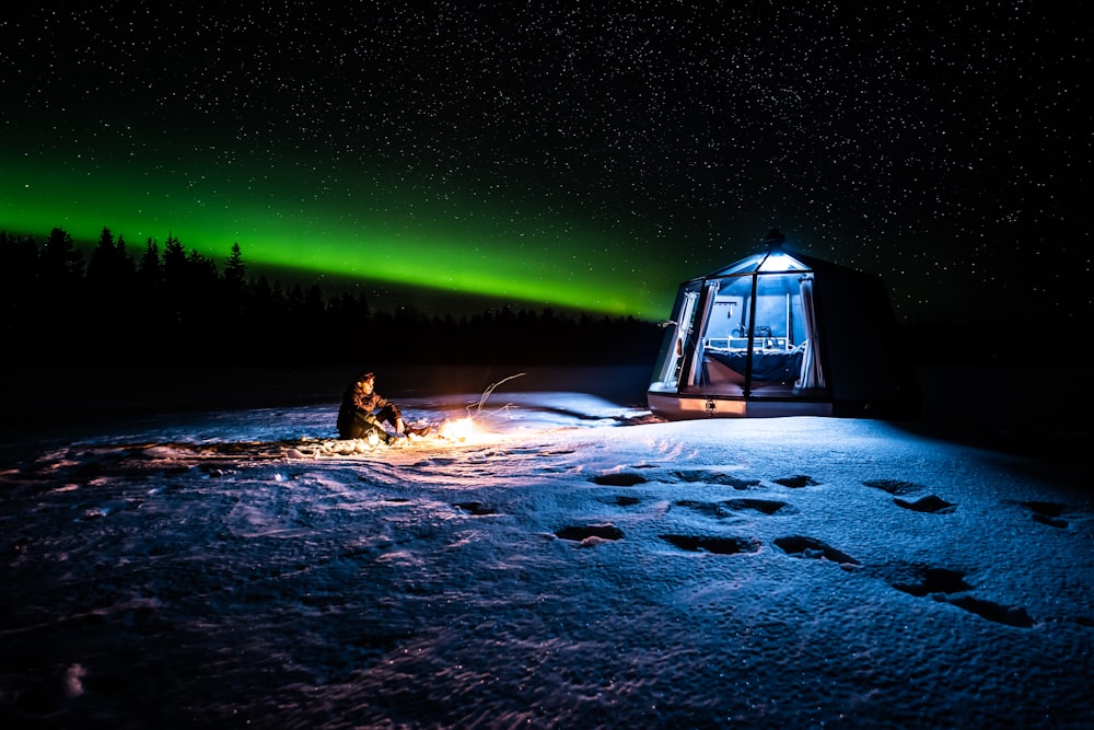 person in black jacket lying on snow covered ground during night time