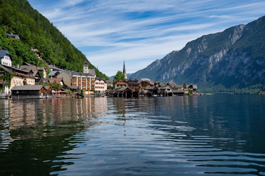 green mountain beside body of water during daytime in Hallstatt Austria Austria