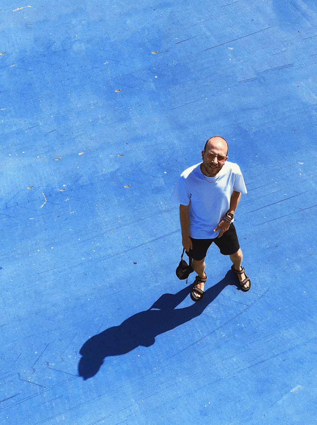 man in white crew neck t-shirt and black shorts sitting on blue concrete floor