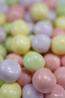 Rows of neatly arranged pastel-colored candies on a textured fabric background