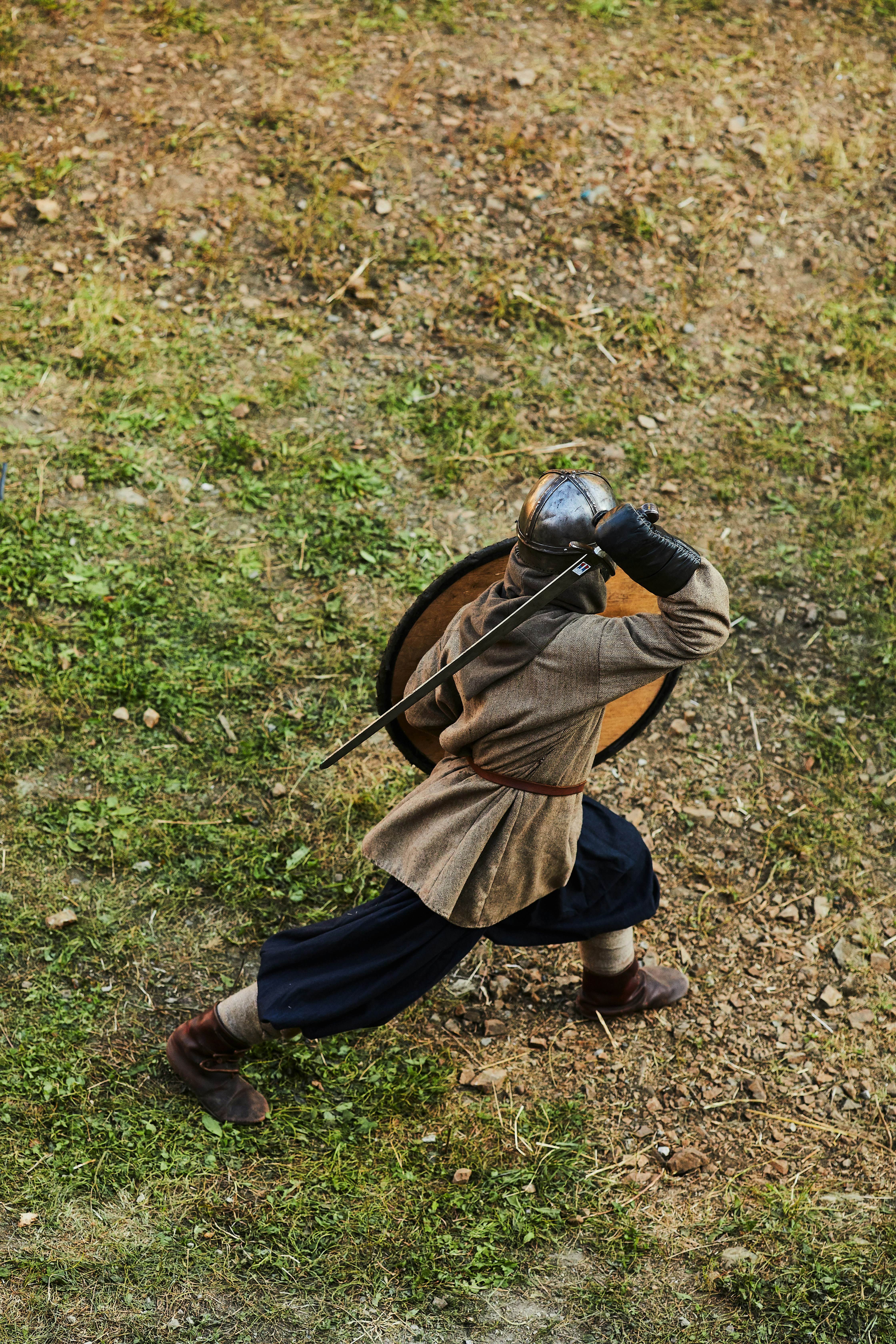 boy in brown jacket and blue pants holding black bow