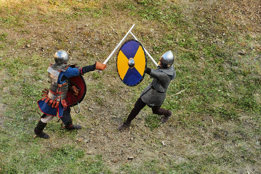 person in blue and red long sleeve shirt and black pants holding blue and black shield