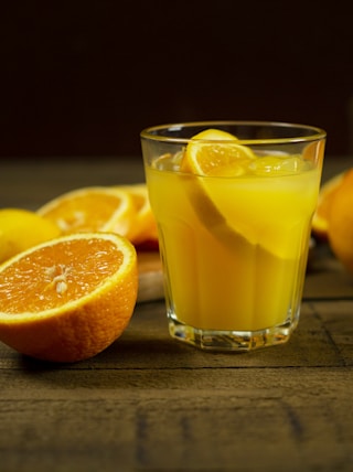 orange juice in clear drinking glass