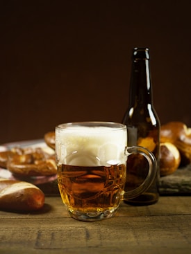 clear glass mug with beer on brown wooden table