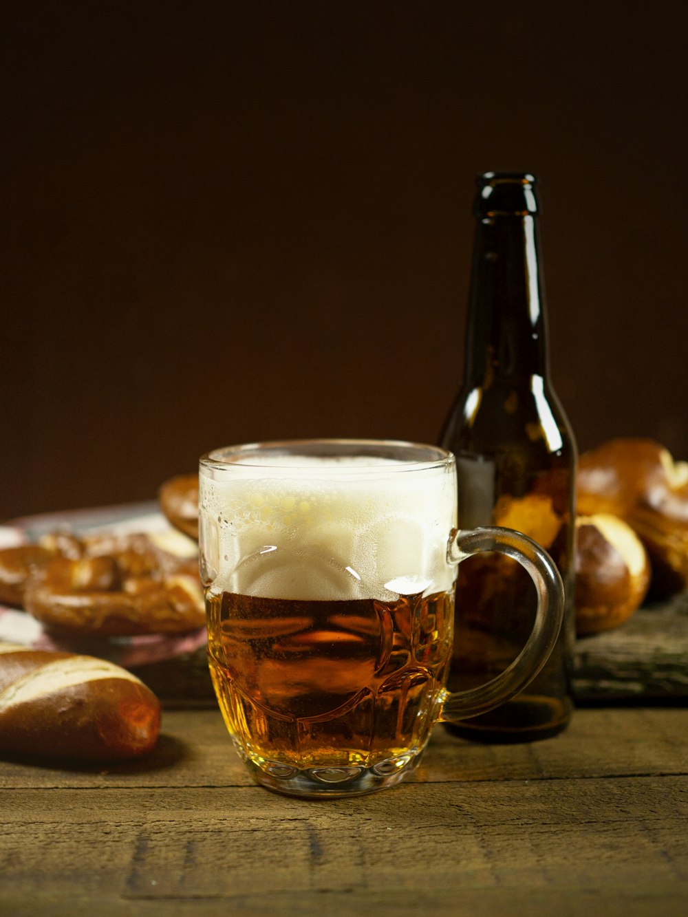 clear glass mug with beer on brown wooden table