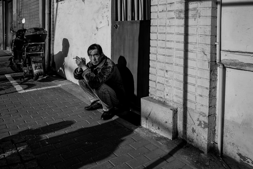 man in black jacket sitting on floor