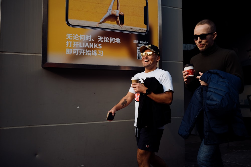 man in black t-shirt and black shorts holding smartphone