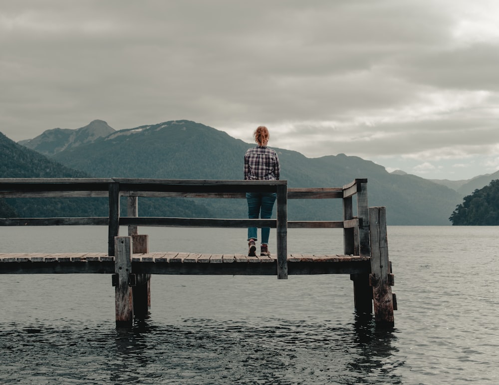 man and woman sitting on wooden dock during daytime