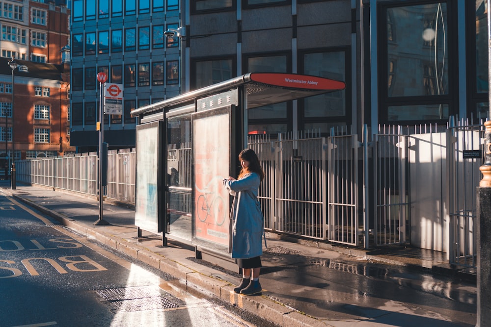 mulher no vestido branco que está perto do edifício durante o dia