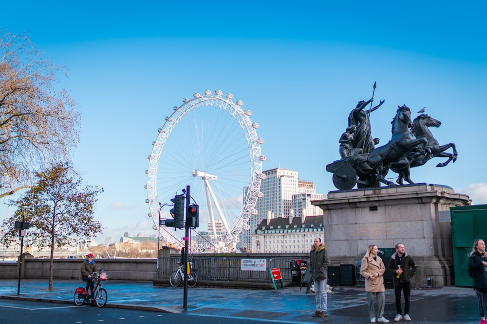 people walking near white ferris wheel during daytime