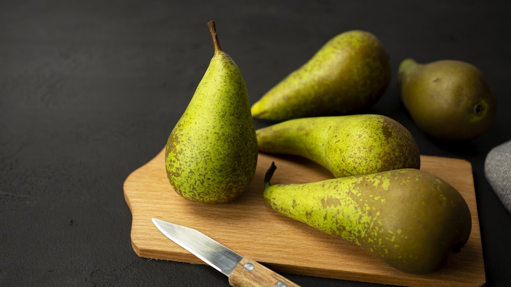 green fruit on brown wooden chopping board