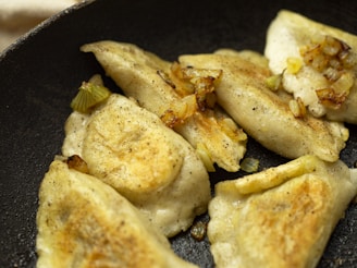 A close-up of kimchi pancakes sizzling on a skillet with golden crispy edges