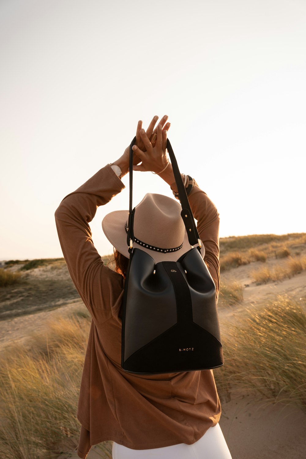 Donna in camicia a maniche lunghe bianca e nera con borsa a tracolla in pelle nera