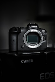 black canon dslr camera on black surface